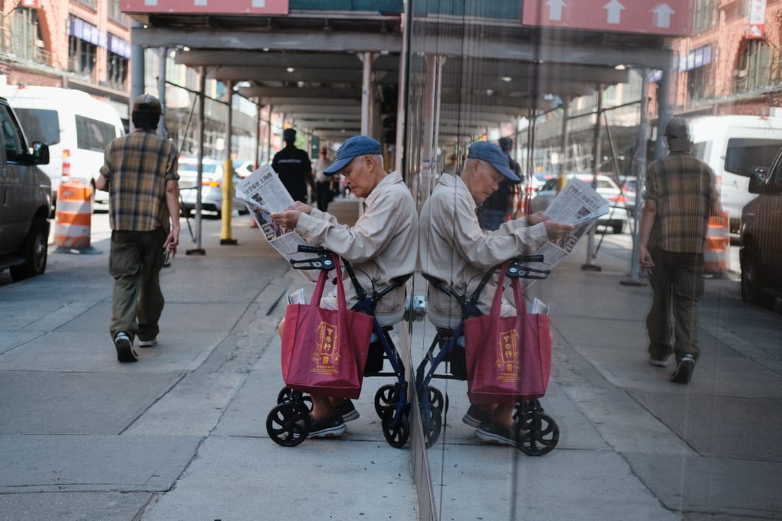 Man reading the newspaper on a corner of Chinatown